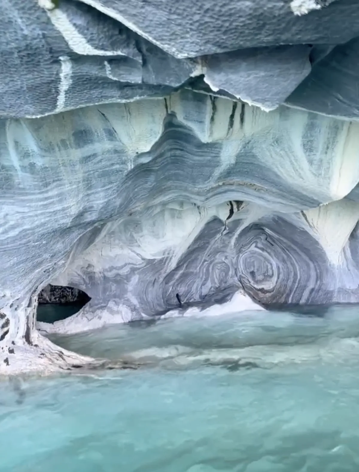 Luz azul en las paredes de mármol de las Cuevas de Mármol, agua glaciar turquesa